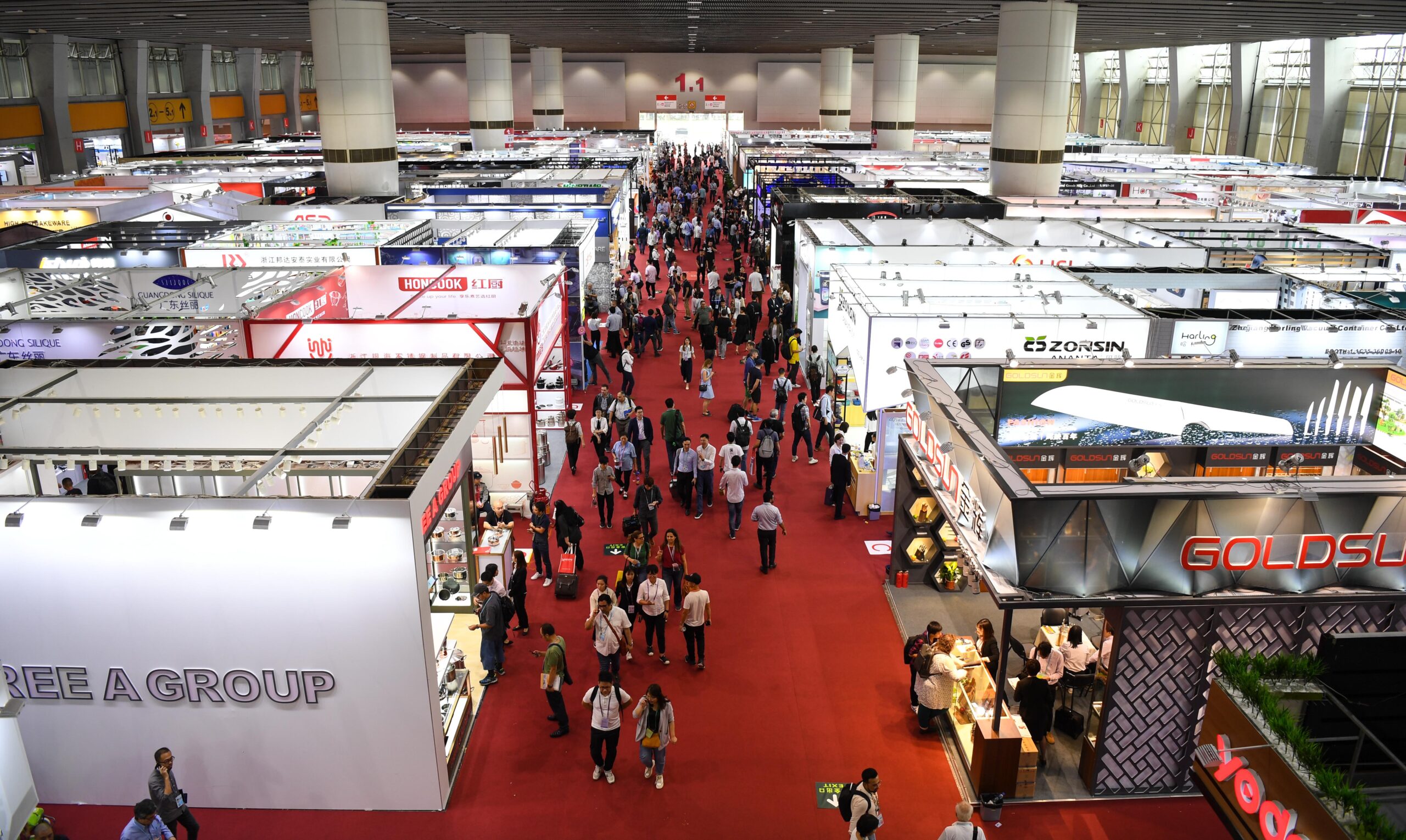 Canton Fair Exhibition Hall, a bustling trade show with colorful booths and visitors